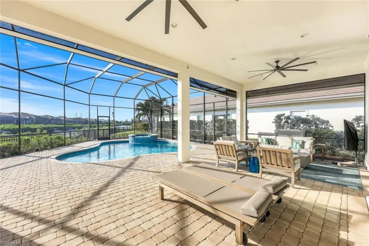 View of swimming pool with a lanai, an in ground hot tub, a patio, and an outdoor living space