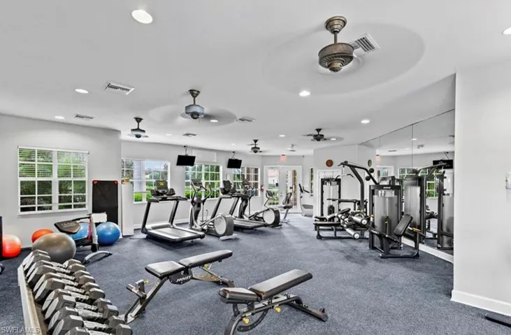 Dedicated fitness center featuring carpet flooring, mirrored wall, recessed lighting, and multiple ceiling fans