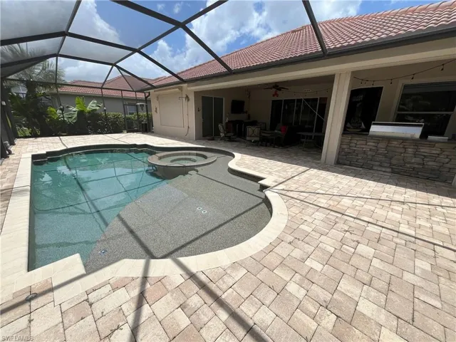 Screened lanai featuring a swimming pool and integrated spa