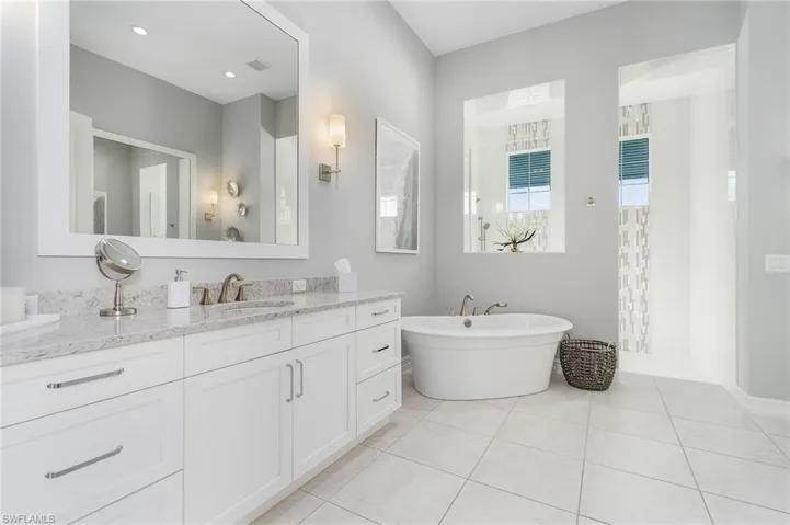 Bathroom featuring tile patterned floors, vanity, a soaking tub, and a walk in shower