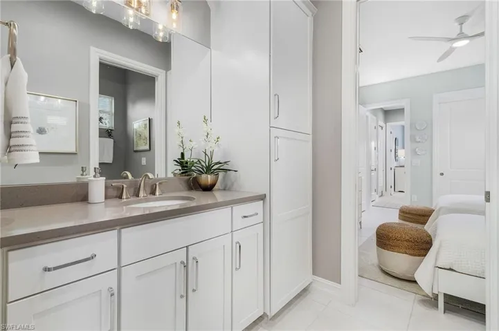 Bathroom featuring tile patterned flooring, vanity, a ceiling fan, and ensuite bath