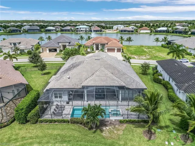 Aerial perspective of suburban area with a large body of water and a pool area