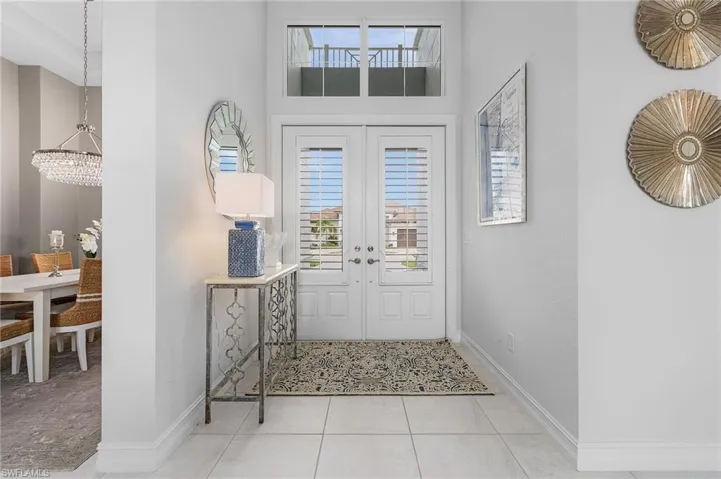 Entryway featuring french doors, tile patterned floors, and a chandelier