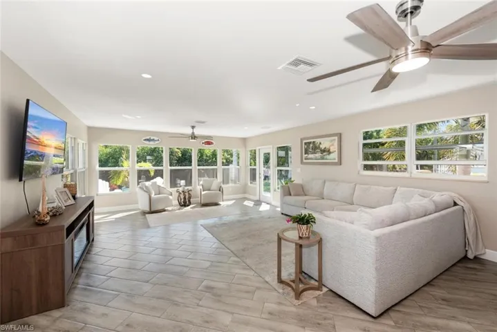 Living room featuring a ceiling fan, wood finish floors, plenty of natural light, and recessed lighting