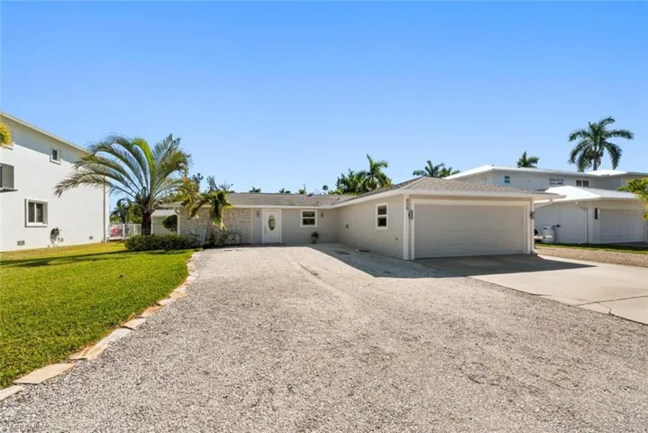 View of front facade featuring driveway, an attached garage, and a front lawn