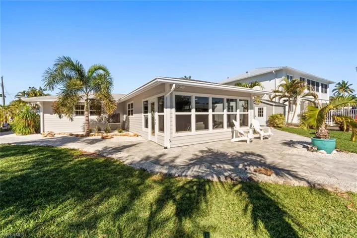 Back of house with a sunroom, a yard, and a patio