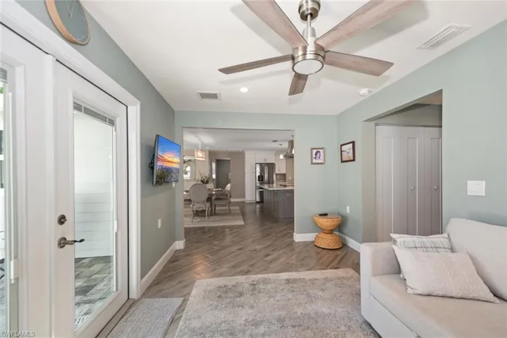 Living area with light wood-style flooring, a ceiling fan, and recessed lighting