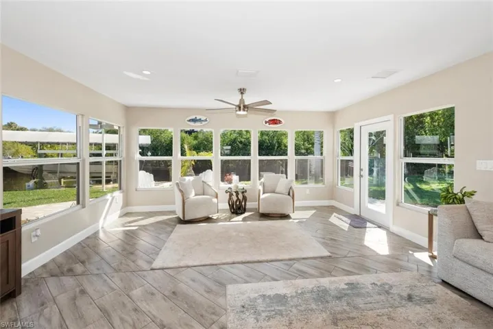 Sunroom / solarium featuring wood finish floors and recessed lighting