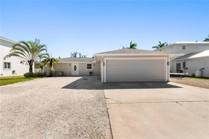 Ranch-style house featuring concrete driveway and an attached garage