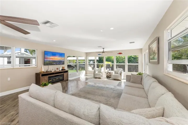 Living room with ceiling fan, recessed lighting, wood finished floors, and a glass covered fireplace