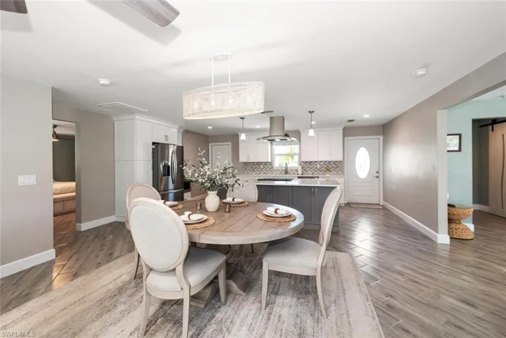 Dining room with a barn door, light wood-style floors, and recessed lighting