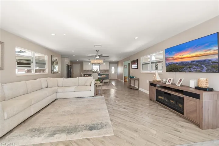 Living room featuring a ceiling fan, recessed lighting, and light wood-style flooring
