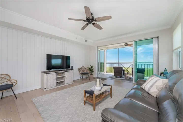 Living room featuring light hardwood / wood-style floors, crown molding, and ceiling fan