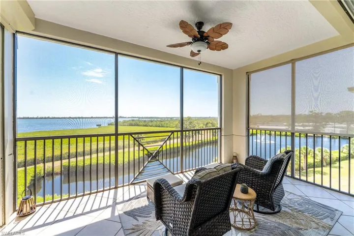 Sunroom / solarium with ceiling fan and a water view