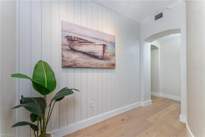 Hall with crown molding and light hardwood / wood-style flooring