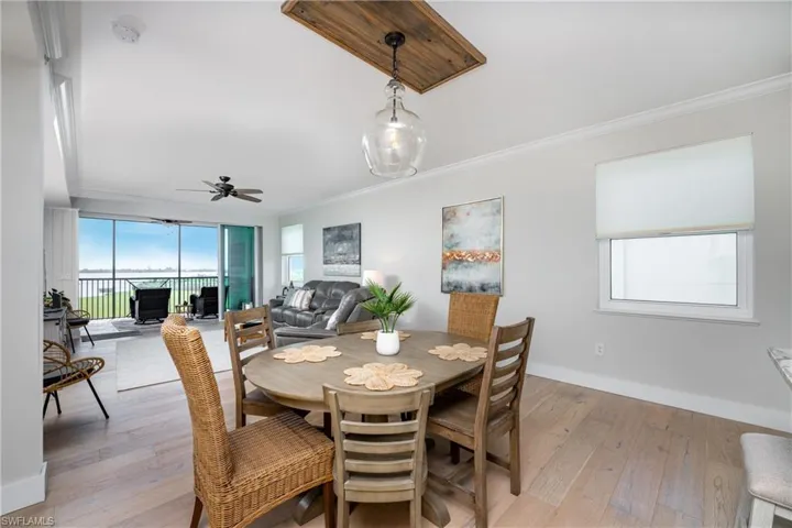 Dining area featuring crown molding, light wood-type flooring, and ceiling fan