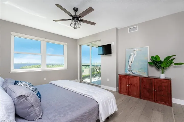 Bedroom with ceiling fan, access to outside, and light hardwood / wood-style flooring