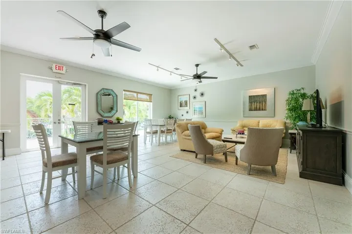Tiled dining room featuring french doors, ceiling fan, rail lighting, and crown molding