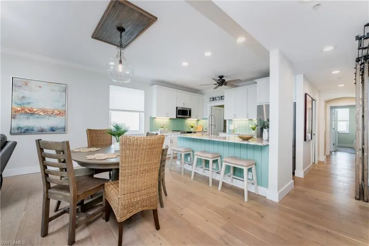 Dining area featuring ornamental molding, ceiling fan, and light hardwood / wood-style flooring