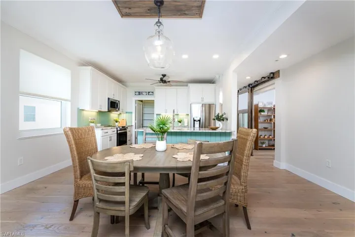 Dining room with ceiling fan, ornamental molding, and light hardwood / wood-style floors