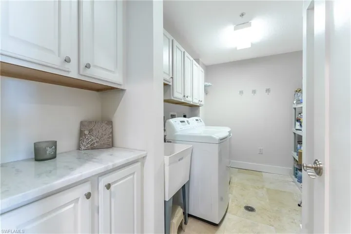 Laundry area featuring cabinets, washer hookup, light tile flooring, and separate washer and dryer