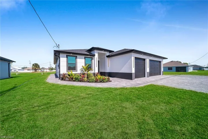 View of front of property featuring a front lawn and a garage