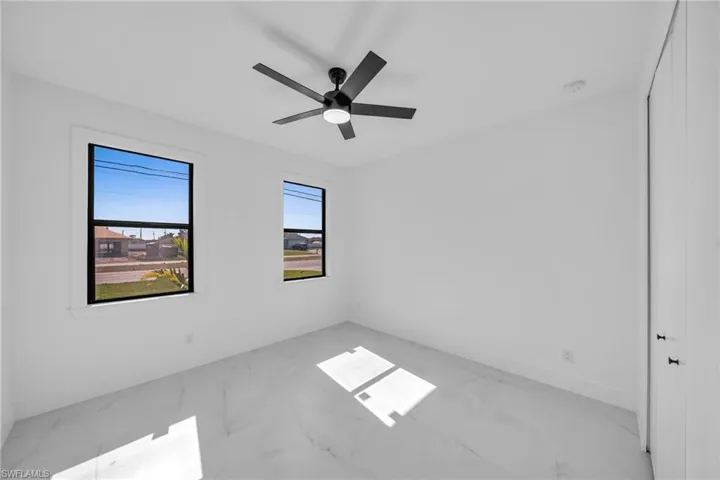 Unfurnished room with a wealth of natural light and ceiling fan