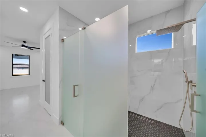 Bathroom with ceiling fan and a shower with door