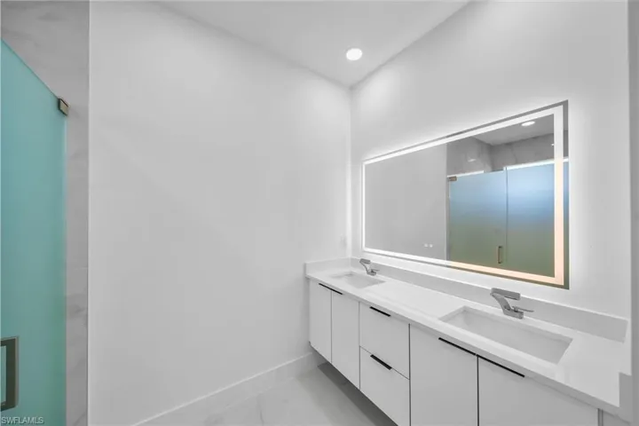 Bathroom with vanity and a shower with door
