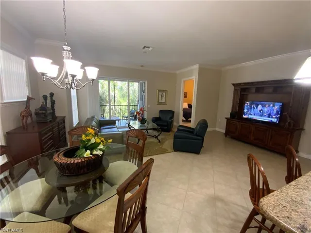 Dining area with crown molding and a chandelier