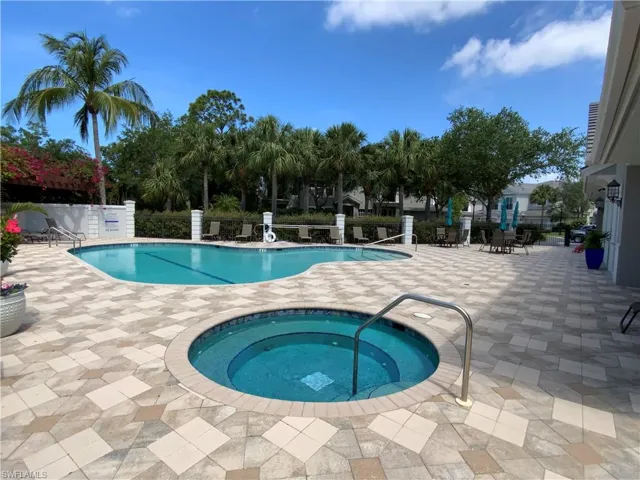 Community pool with a patio area and a community hot tub
