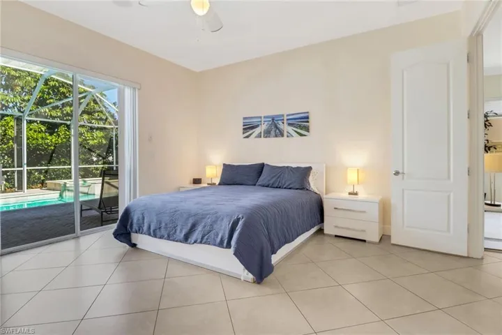 Bedroom with access to exterior, light tile patterned floors, and ceiling fan