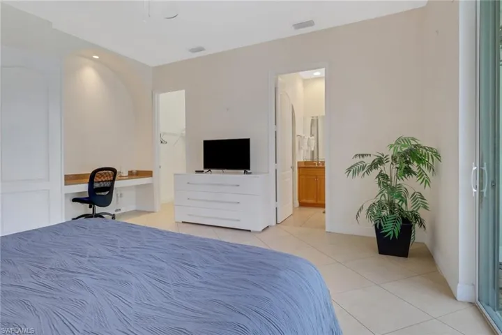 Tiled bedroom with connected bathroom and built in desk