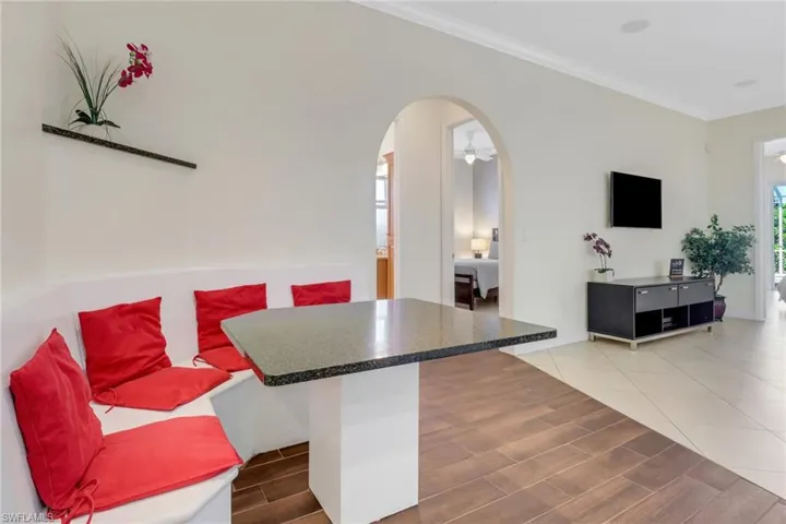 Kitchen with a kitchen breakfast bar, ceiling fan, crown molding, and hardwood / wood-style flooring