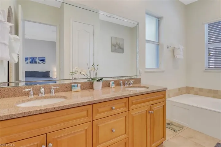 Bathroom featuring vanity, tile patterned floors, and a bathtub