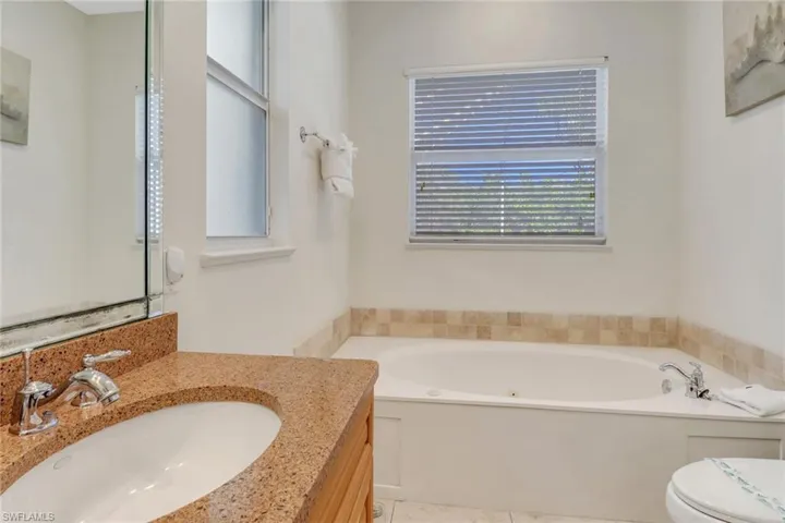 Bathroom with tile patterned flooring, vanity, toilet, and a tub