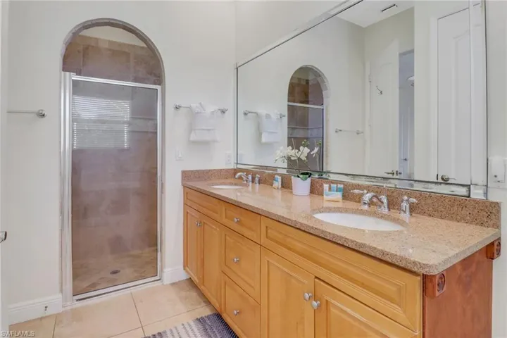 Bathroom with vanity, tile patterned floors, and an enclosed shower