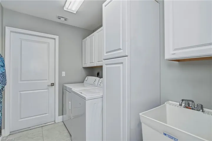 Inside Laundry room with sink and lots of cabinets for storage