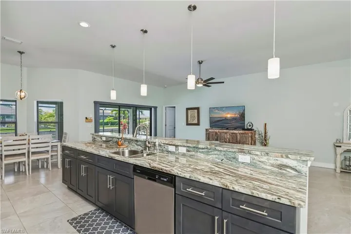long granite kitchen island looking towards eat in kitchen area and slider to lanai