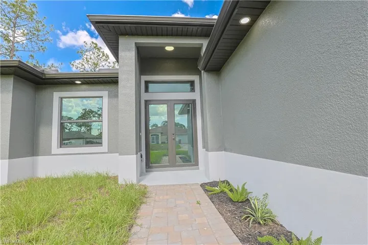 Entrance to property featuring stucco siding and french doors
