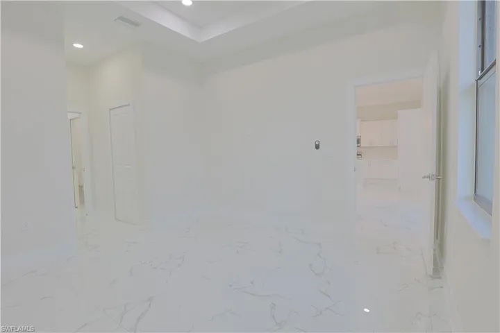 Unfurnished room featuring light marble finish floors and recessed lighting