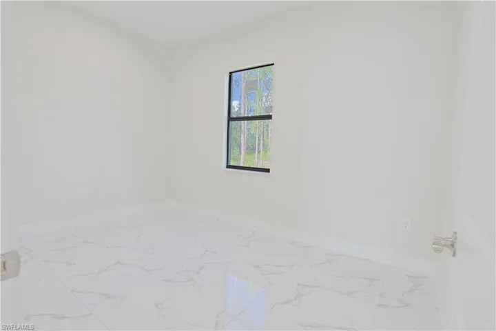 Spare room featuring baseboards and marble finish floors