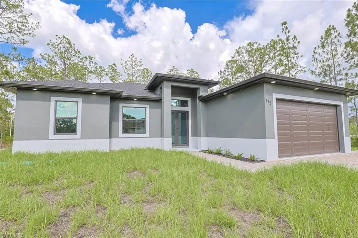 Prairie-style house with stucco siding, a garage, and driveway