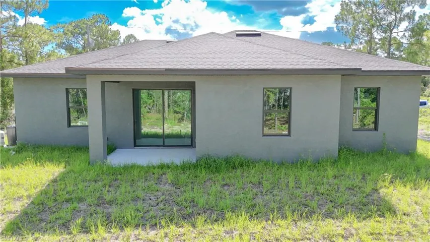 View of property exterior featuring a shingled roof and stucco siding