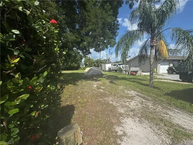 View of yard with driveway and a garage