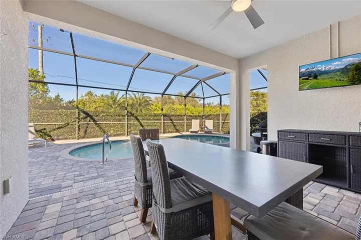 View of patio featuring ceiling fan and a lanai
