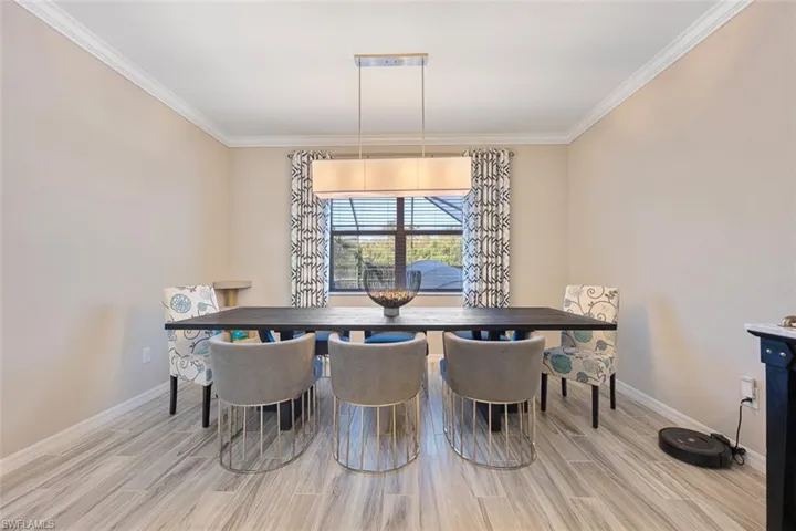 Dining room featuring ornamental molding and light hardwood / wood-style floors