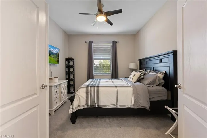 Den with ceiling fan and carpet flooring