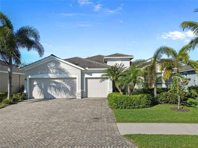 View of front of home with a front yard and a garage