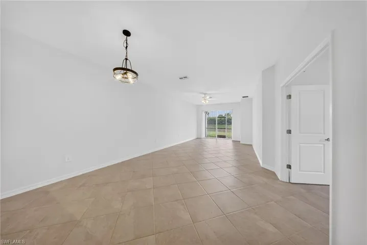Empty room with ceiling fan and light tile patterned floors